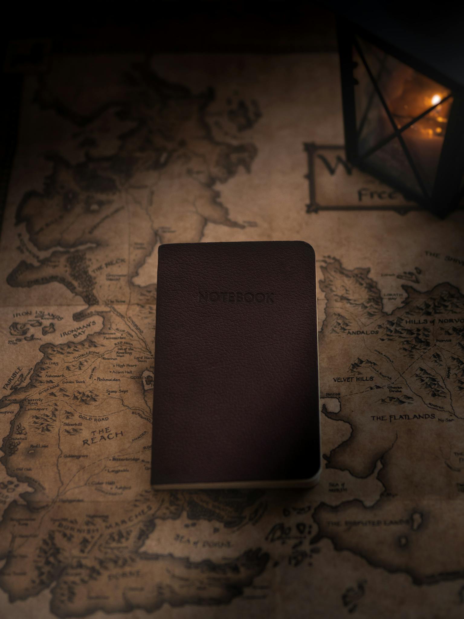 Discover exploration themes with a notebook and lantern on an antique map.